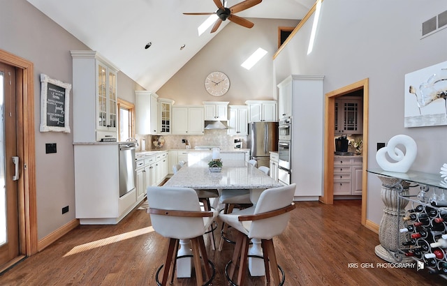 dining area with high vaulted ceiling, ceiling fan, and dark hardwood / wood-style floors