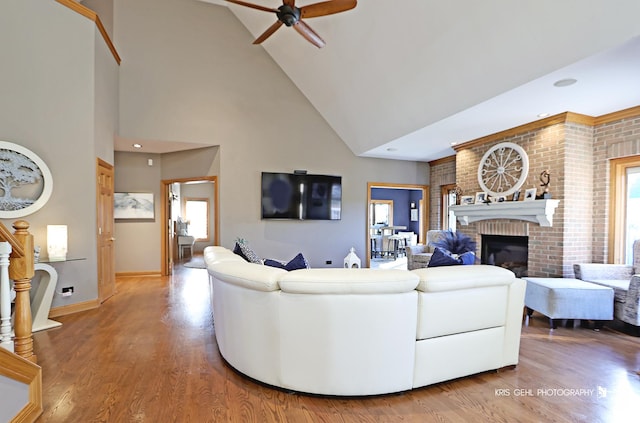 living room featuring ceiling fan, plenty of natural light, wood-type flooring, and a fireplace