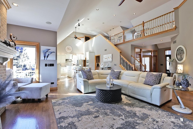 living room featuring ceiling fan, a high ceiling, and dark hardwood / wood-style flooring