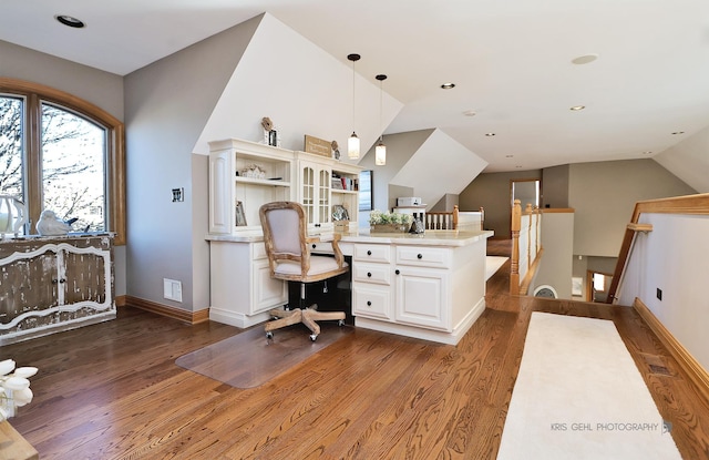 home office with built in desk, dark hardwood / wood-style flooring, and lofted ceiling