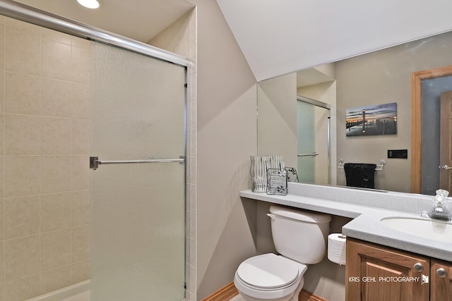 bathroom with a shower with shower door, toilet, and vanity