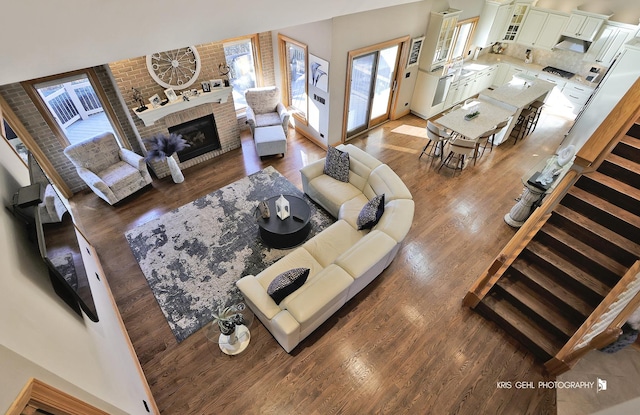 living room with dark wood-type flooring and a brick fireplace