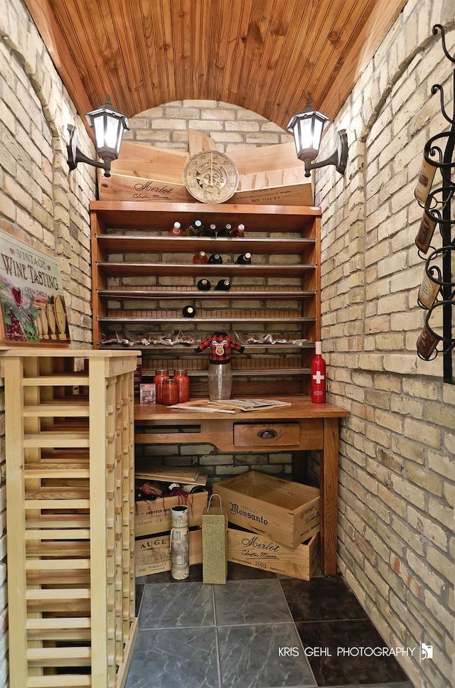 wine cellar with brick ceiling, vaulted ceiling, brick wall, and wooden ceiling