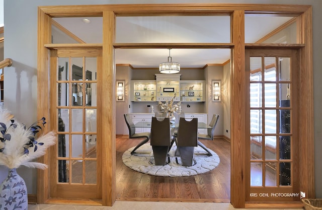 dining room with a chandelier, ornamental molding, and hardwood / wood-style floors