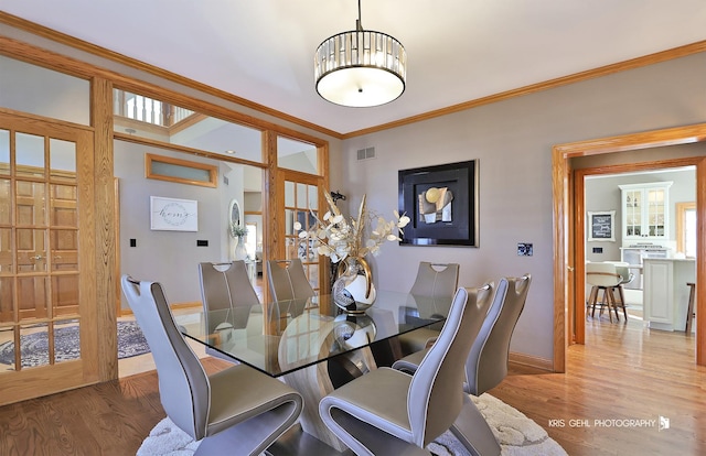 dining room with ornamental molding and wood-type flooring