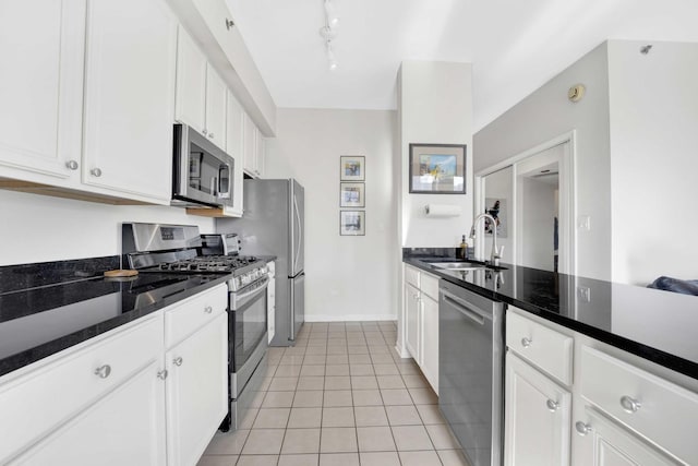 kitchen with light tile patterned floors, white cabinets, appliances with stainless steel finishes, and sink