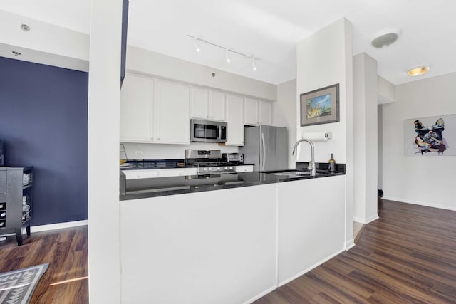 kitchen featuring dark wood-type flooring, sink, white cabinetry, and appliances with stainless steel finishes