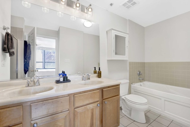 bathroom featuring a bathtub, tile patterned floors, vanity, and toilet