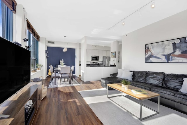 living room with rail lighting and hardwood / wood-style floors