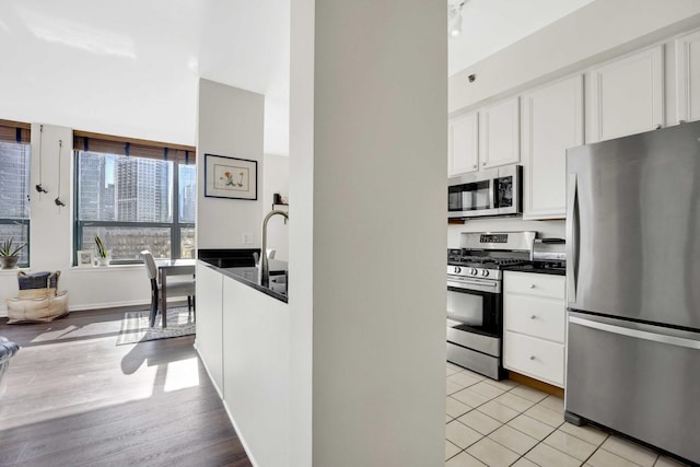 kitchen with light tile patterned floors, white cabinets, and appliances with stainless steel finishes