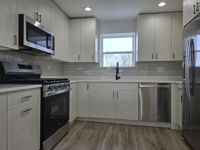 kitchen featuring dark hardwood / wood-style flooring, sink, white cabinetry, and stainless steel appliances