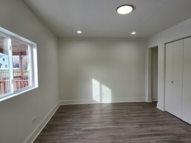 unfurnished bedroom with dark hardwood / wood-style flooring and a closet