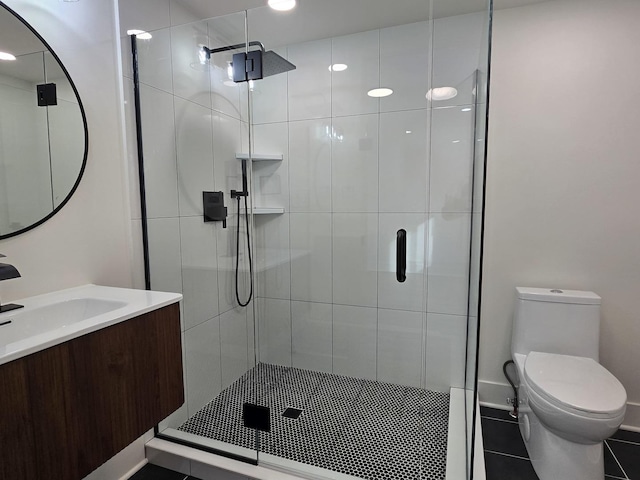 bathroom featuring an enclosed shower, vanity, tile patterned floors, and toilet