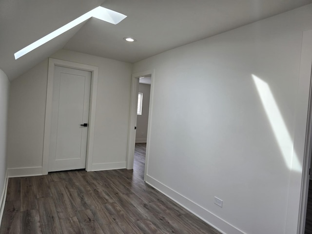 bonus room featuring dark hardwood / wood-style floors and vaulted ceiling with skylight