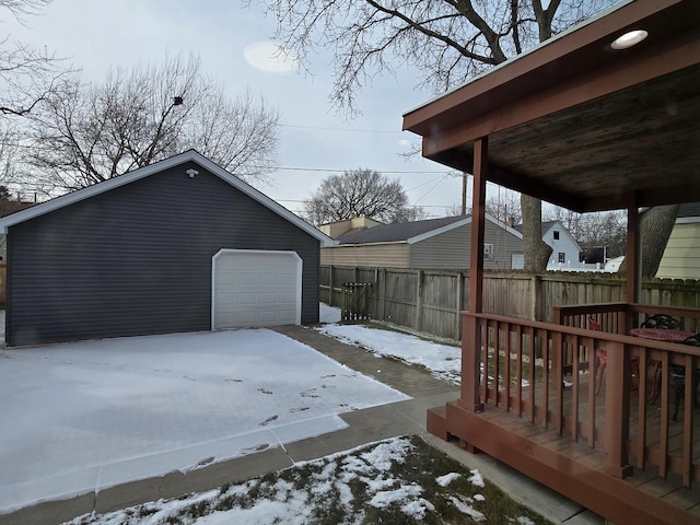 snow covered deck featuring a garage and an outdoor structure