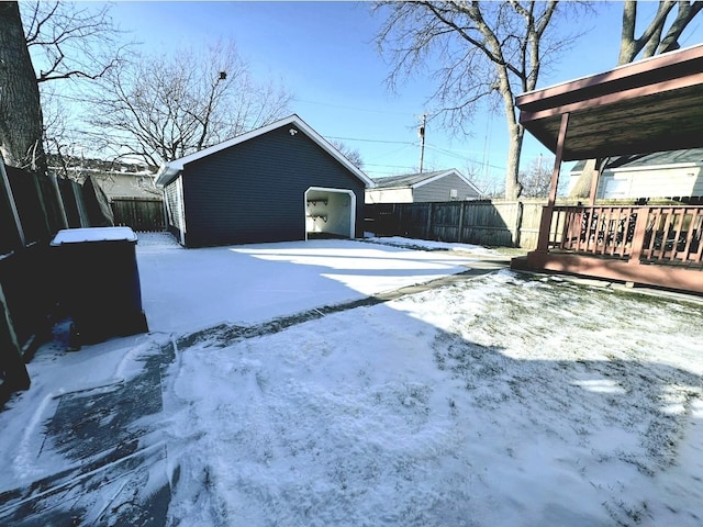 yard layered in snow with a garage and an outdoor structure