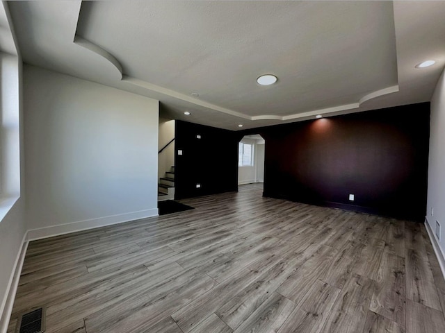 interior space with light hardwood / wood-style floors and a raised ceiling