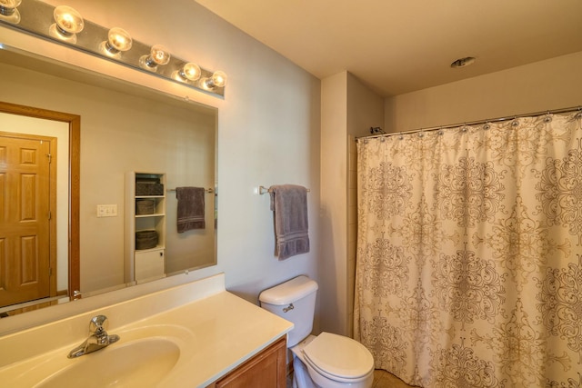 bathroom with toilet, vanity, and walk in shower