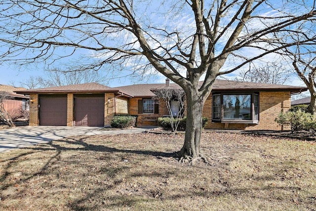 single story home with a garage, a chimney, concrete driveway, and brick siding