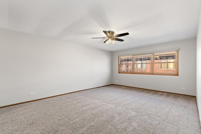 empty room with carpet, baseboards, and a ceiling fan