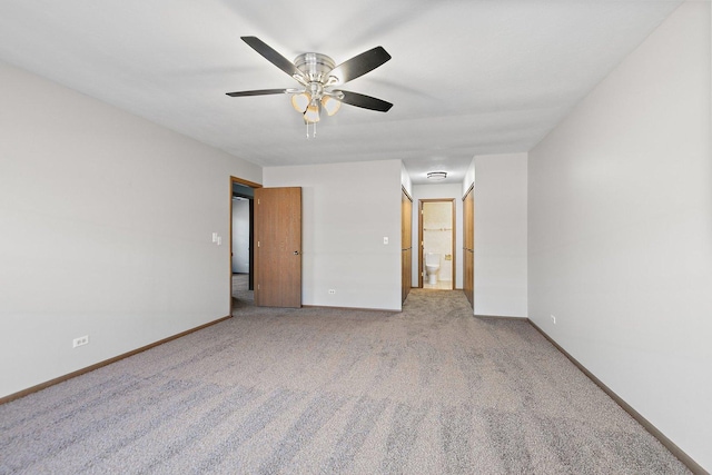 unfurnished bedroom featuring light carpet, a ceiling fan, baseboards, and connected bathroom