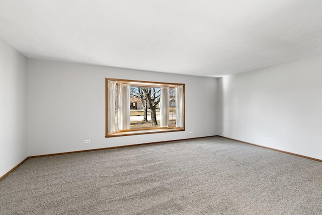 carpeted spare room featuring baseboards