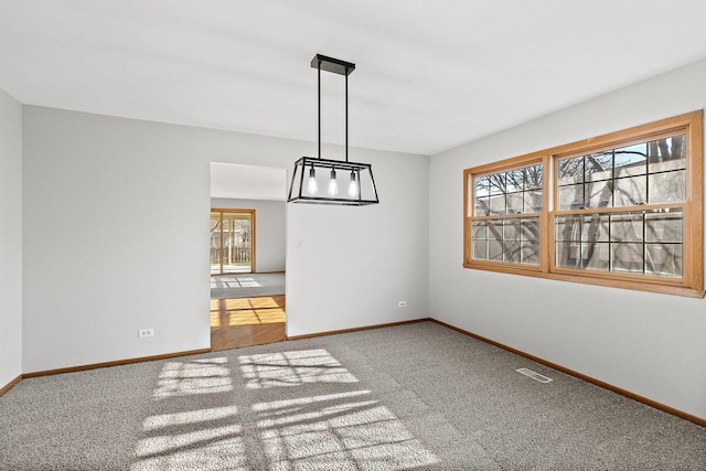 unfurnished dining area featuring carpet, visible vents, and baseboards