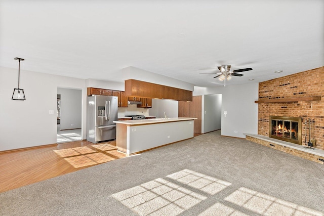 kitchen with open floor plan, stainless steel appliances, light countertops, and decorative light fixtures