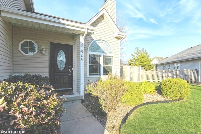 view of exterior entry with a lawn