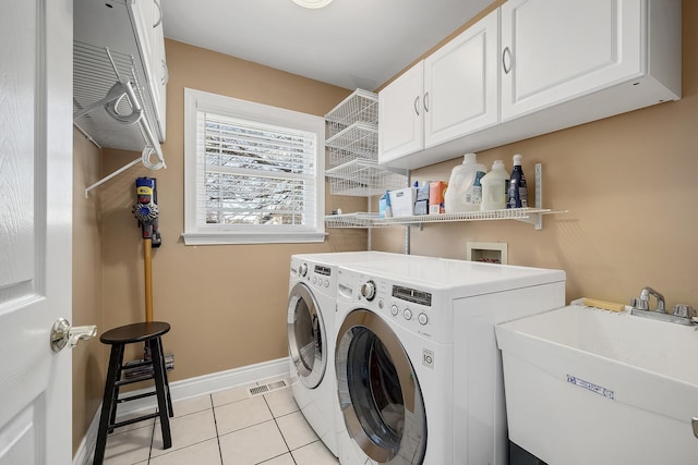 laundry room with cabinets, sink, light tile patterned floors, and independent washer and dryer