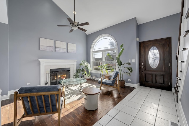 foyer featuring light tile patterned flooring, ceiling fan, lofted ceiling, and a fireplace