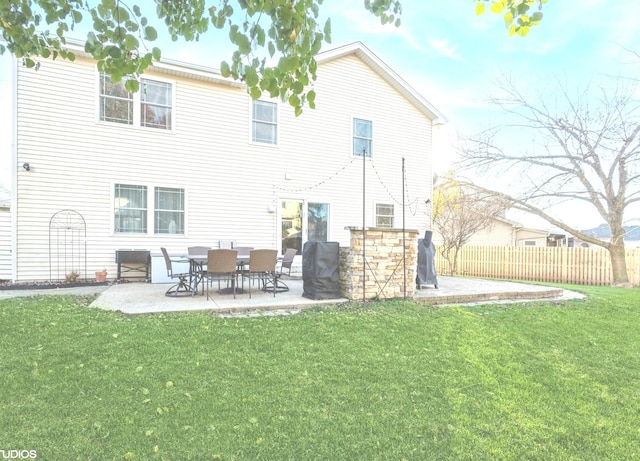 rear view of house featuring a yard and a patio