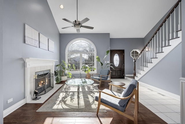 living room with a tiled fireplace, hardwood / wood-style flooring, and ceiling fan