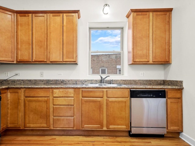 kitchen featuring sink, stainless steel dishwasher, light hardwood / wood-style flooring, and dark stone countertops