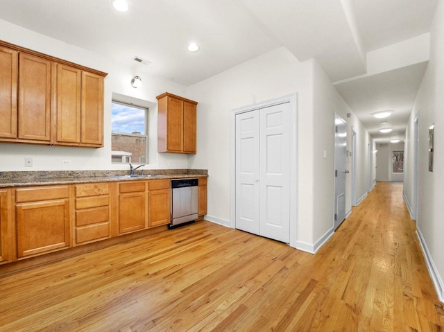 kitchen featuring sink, light hardwood / wood-style flooring, dark stone counters, and dishwasher