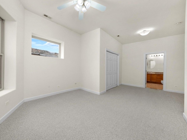 unfurnished bedroom with carpet floors, ensuite bathroom, a closet, and ceiling fan