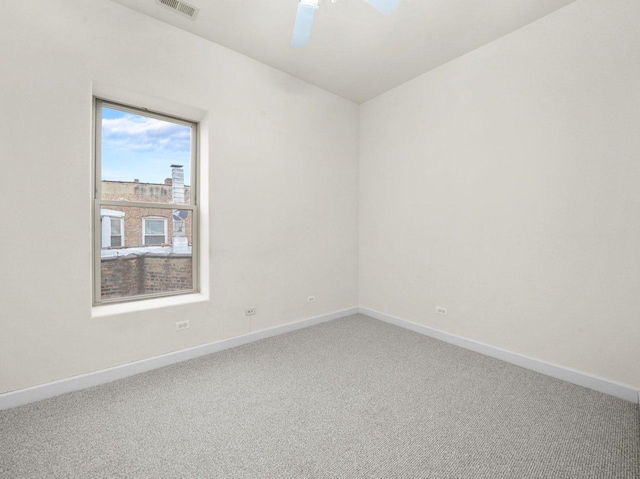 carpeted spare room with ceiling fan