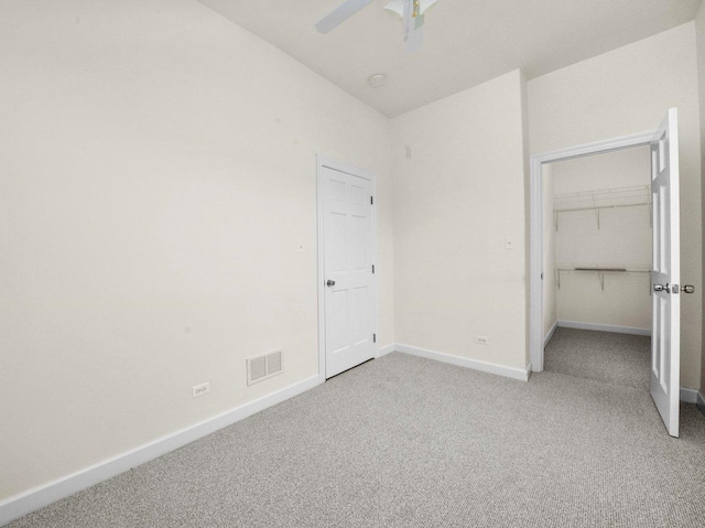 unfurnished bedroom featuring light carpet, a closet, and ceiling fan