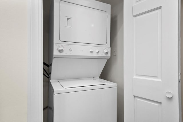 washroom featuring stacked washer / drying machine