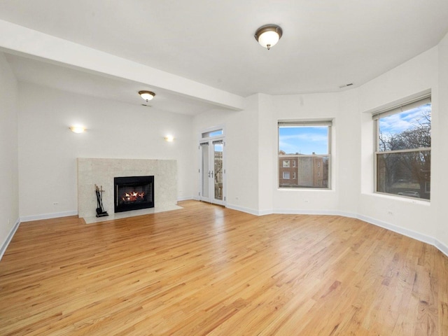 unfurnished living room featuring light hardwood / wood-style floors and a high end fireplace