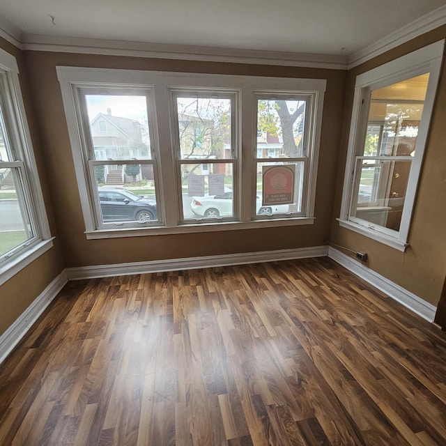 spare room featuring dark hardwood / wood-style flooring and crown molding