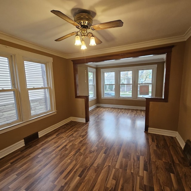 empty room with dark wood-type flooring, crown molding, and ceiling fan