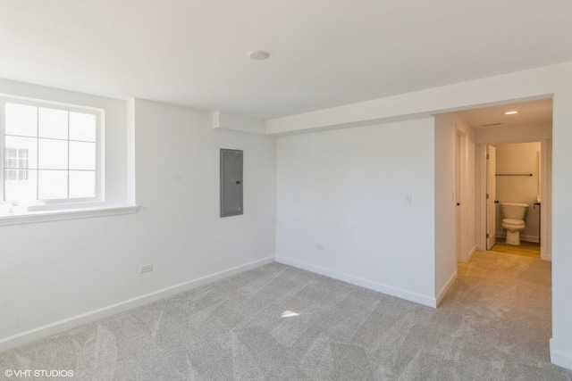 unfurnished room featuring light carpet and electric panel