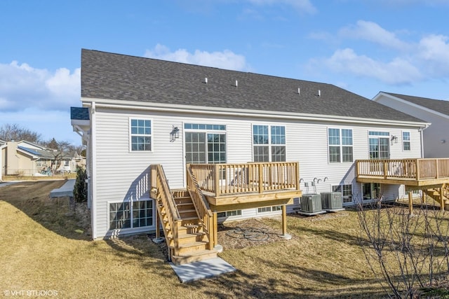 rear view of house featuring central air condition unit, a wooden deck, and a yard