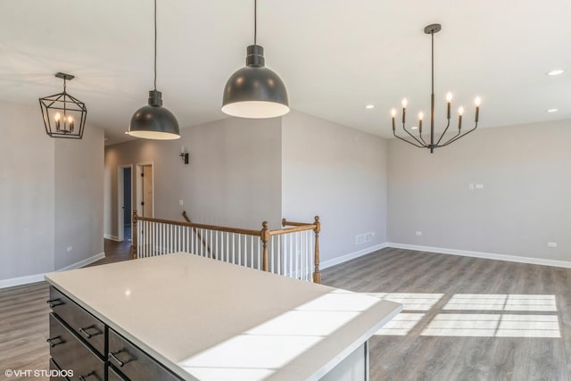 kitchen with pendant lighting, hardwood / wood-style floors, and an inviting chandelier