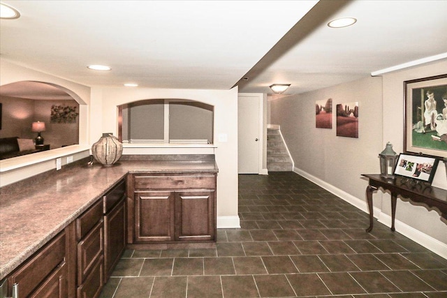 kitchen featuring baseboards, dark brown cabinetry, and recessed lighting