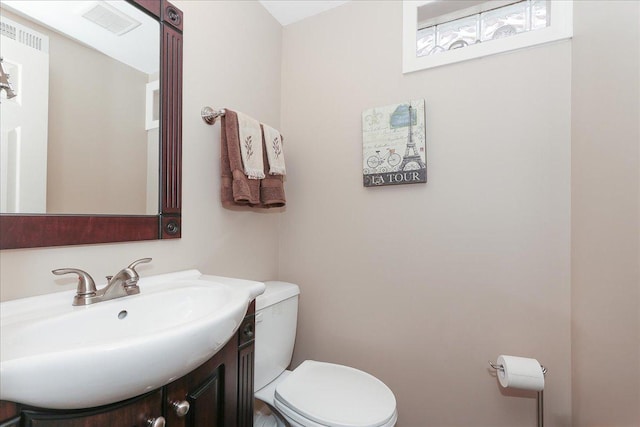 bathroom with vanity, toilet, and visible vents