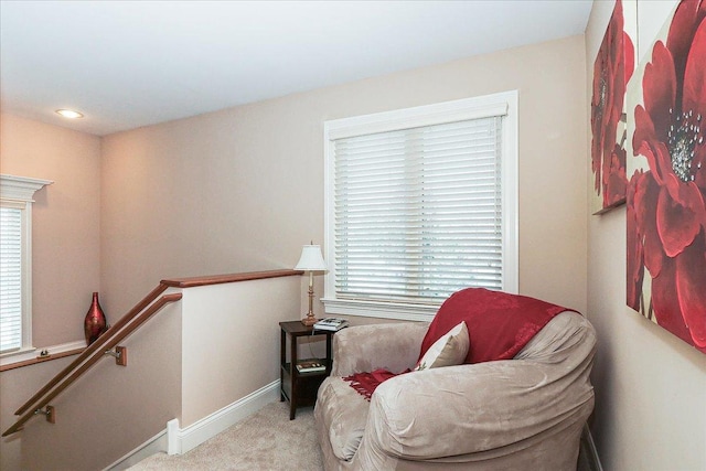 sitting room with carpet floors, baseboards, an upstairs landing, and plenty of natural light