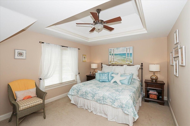 bedroom featuring a raised ceiling, baseboards, light carpet, and a ceiling fan