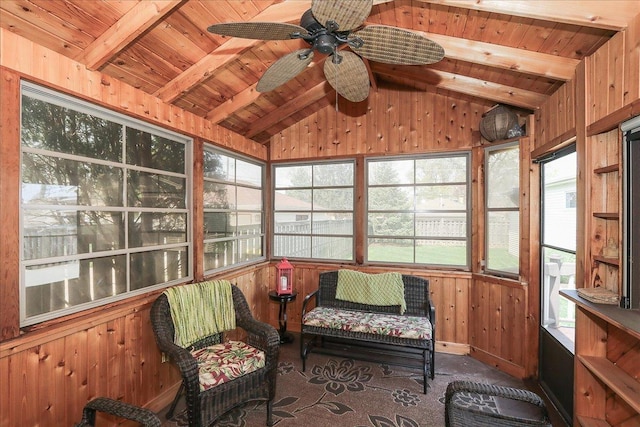 sunroom with ceiling fan and beam ceiling
